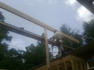 Carpenter setting a ridge beam over a new addition frame — Ice Dam Removal by Roofing Brothers in Misenheimer