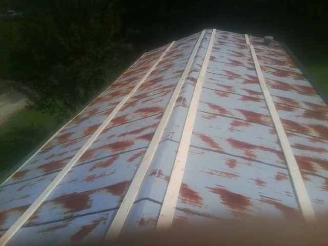 Rusted metal roof panels with new wood purlins before replacement — Storm Damage Roof Repair in Misenheimer by Roofing Brothers