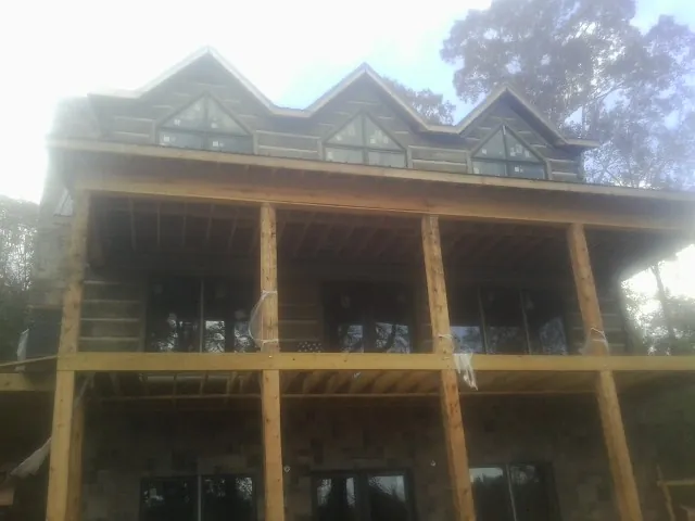 Dormers and porch framing on a large log home under construction — Roof Coating work by our crew in Misenheimer