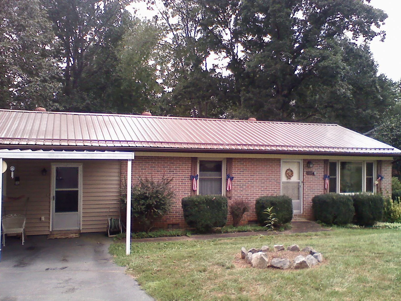 Bronze metal roof and carport on a brick ranch home — Roof Repair work by our crew in Misenheimer